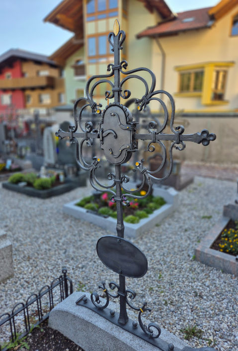 traditionelles Grabkreuz mit geschwungenen Ornamenten