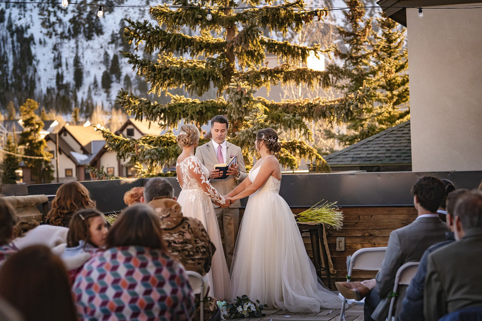 beautiful photo of two brides at the alter during LGBTQ wedding ceremony at the 10 Mile Music Hall in Frisco, Colorado on their wedding day