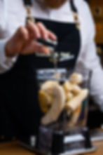Amylase being poured into a blender with bananas