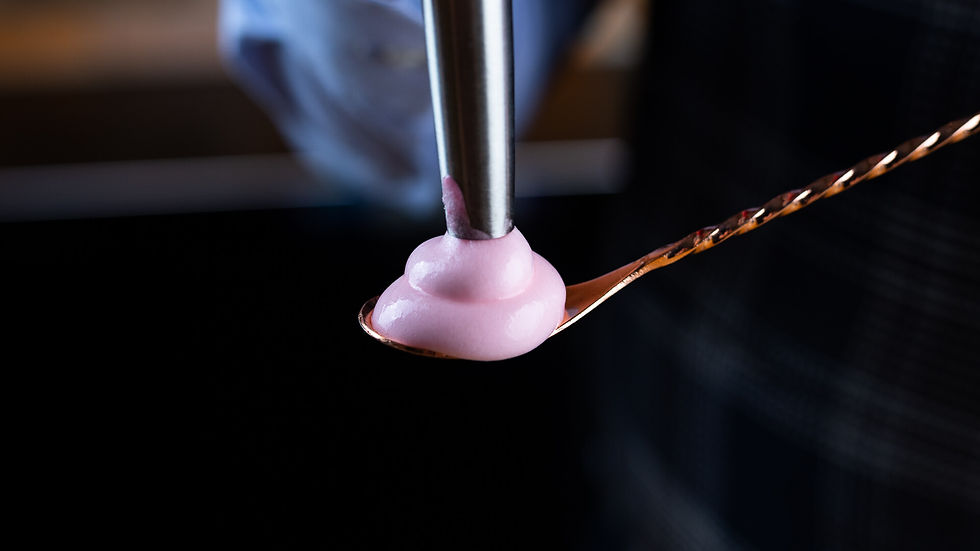 Rosé foam being served on a bar spoon