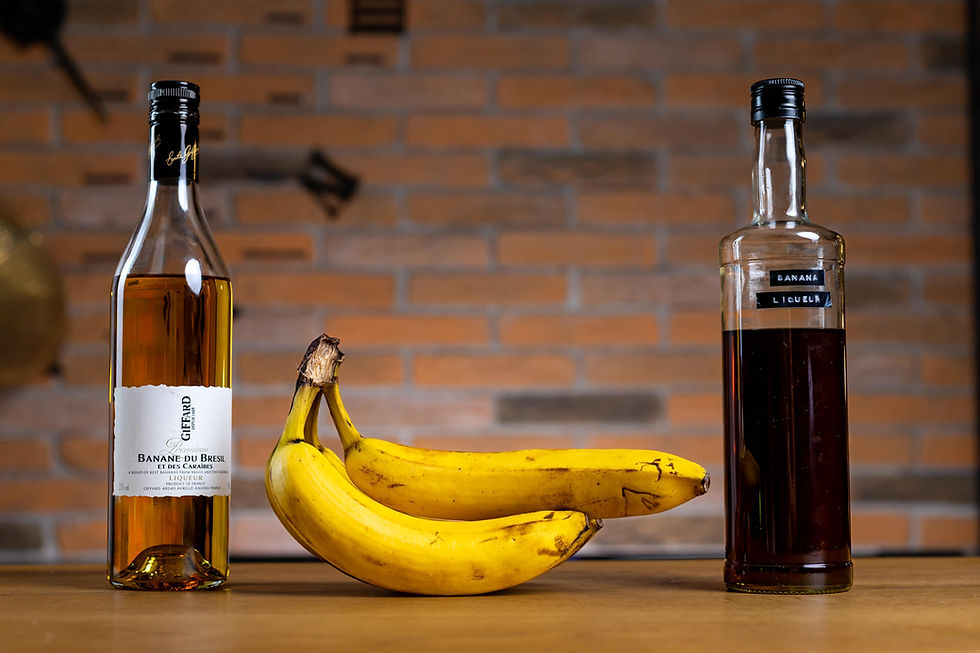 Giffard banana liqueur, a bunch of bananas, and homemade banana liqueur