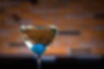 A baby blue onion inside a sparkling dry martini