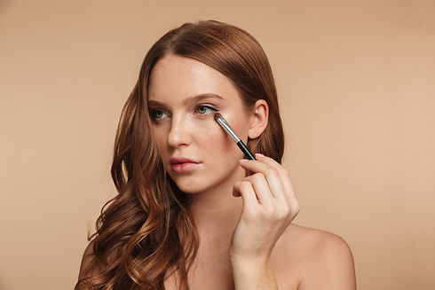 beauty-portrait-of-mystery-smiling-ginger-woman-with-long-hair-looking-away-while-applying