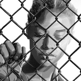 A thoughtful woman gazes through prison fence.