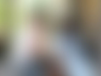 A man and woman sitting facing each other at an outside table.