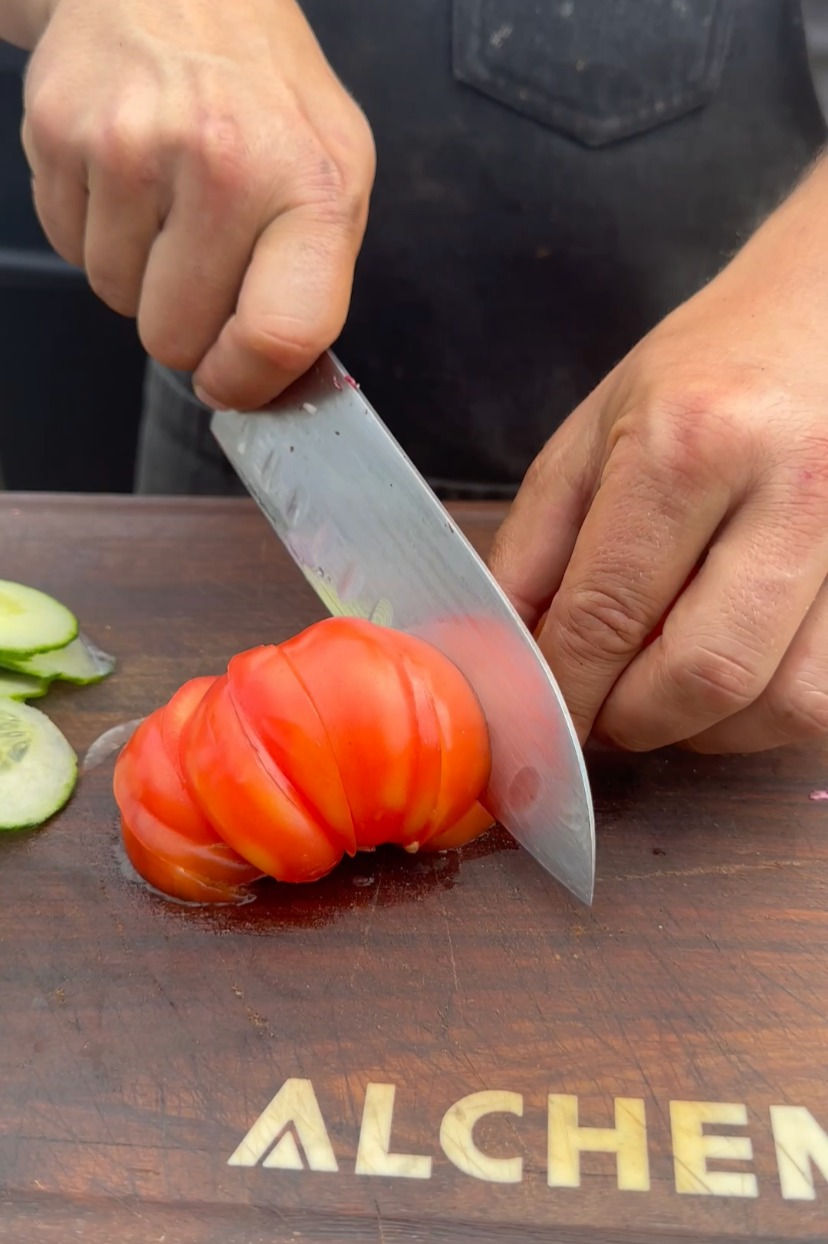 cutting an heirloom tomato into chunks