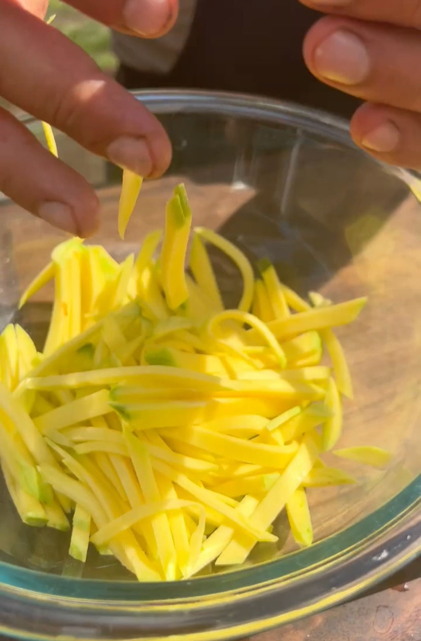 think sliced mango being put into a large bowl