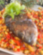 grilled whole sea bream with sweet chili hear sauce on a bed of grilled pineapple salsa