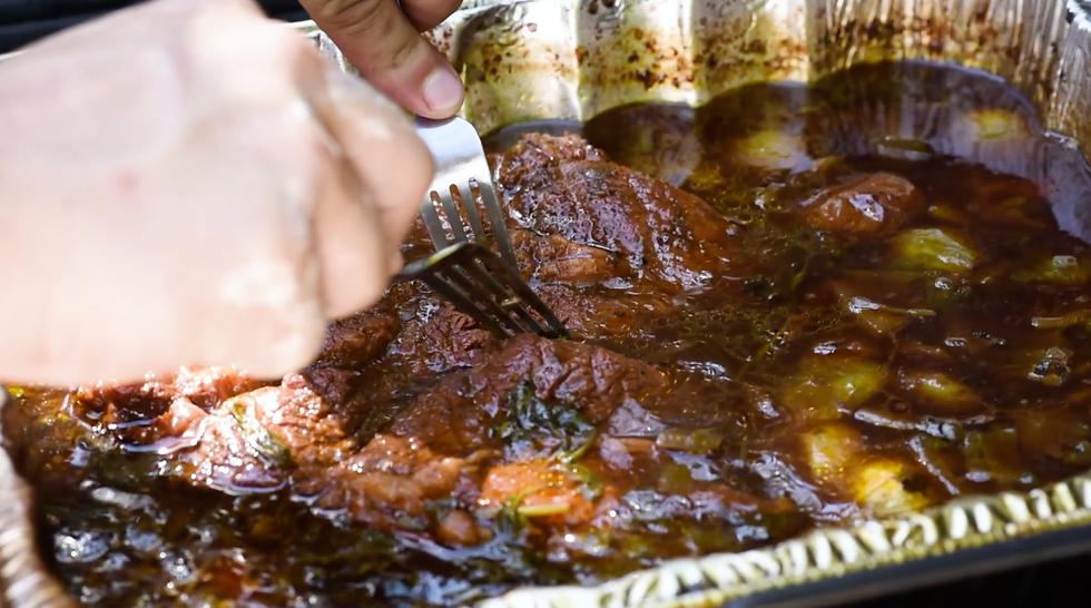 braised beef blade being pulled apart with two forks
