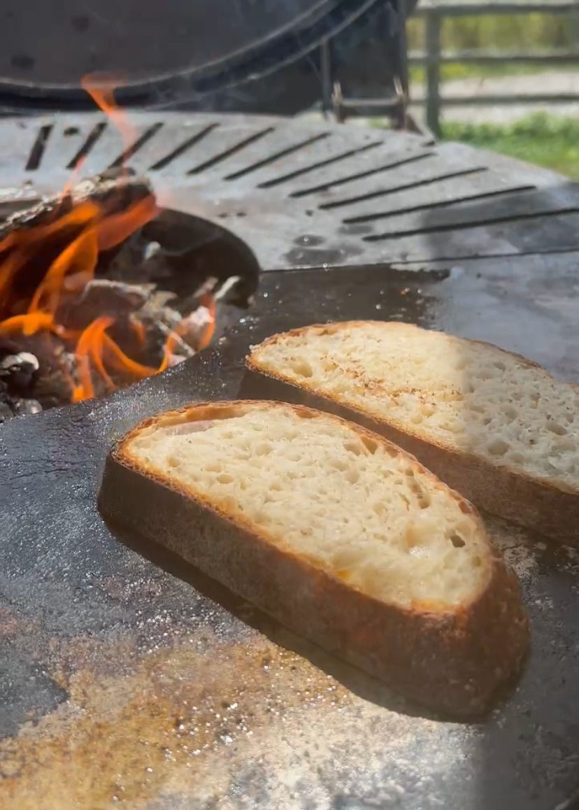 two sourdough bread slices toasting on the plancha