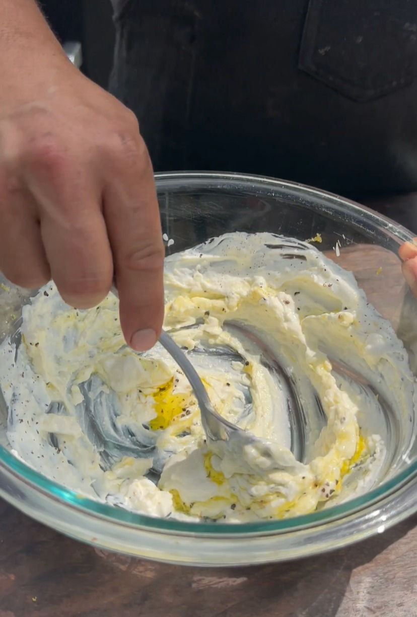 mixing Greek yogurt, feta, lemon zest, garlic, salt and pepper in a bowl