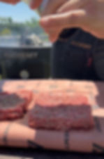 seasoning the burger patties with black pepper