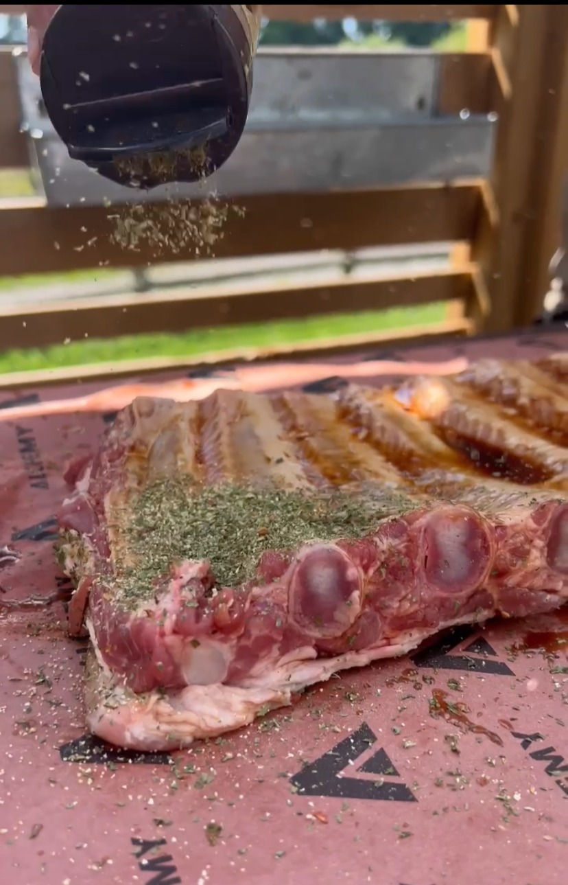 pork side ribs being seasoned with Alchemy Green Rub