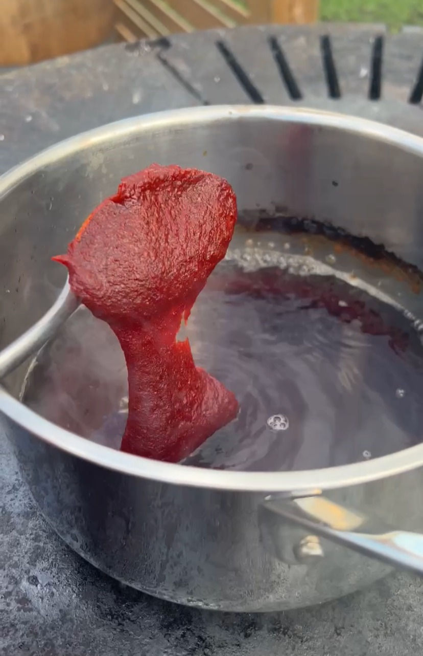 making gochujang bbq sauce by putting gochujang in a pot with melted brown sugar in boiling water