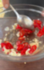 chopped garlic and Italian chili pepper in a bowl with apple cider vinegar