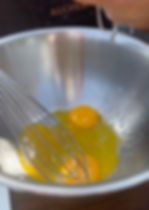 egg yolks in a bowl with lemon juice being squeezed in to make Hollandaise sauce