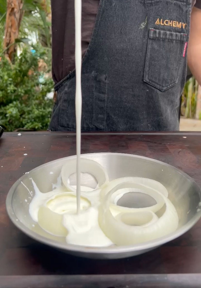 slices of onions being soaked in buttermilk