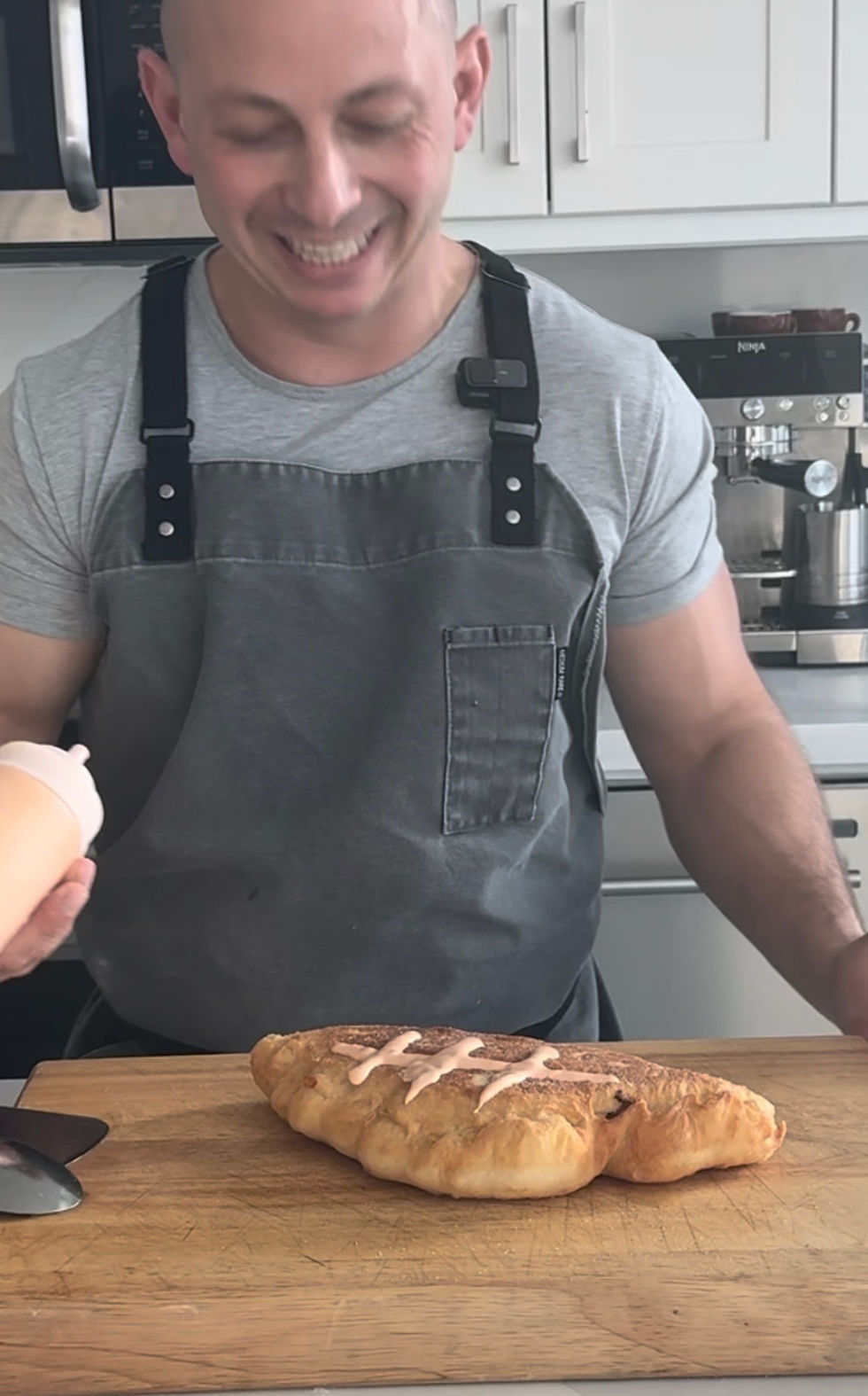 chef Matt Basile looking proudly at the football laces he just drew on his panzerotto with a squeeze bottle