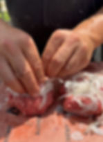 pressing thinly shaved onions into the top of the ground beef balls