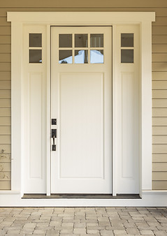 White front door with small square decorative windows and flower pots.jpg