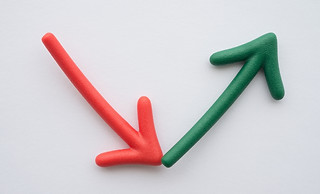 Image of a red arrow angled downward and green arrow angled upward.