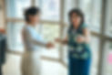 A young woman in a light blue top extends her arms, following instructions from Ariel Weis