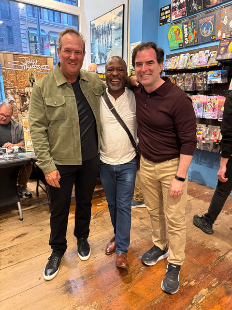 John Stanisci in brown sweater standing next to two OGN fans at a Forbidden Planet signing event