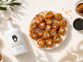 Plate of crispy feta bites drizzled with high-phenolic extra virgin olive oil, garnished with black sesame seeds and honey, served alongside a bottle of PJ Kabos Family Reserve Medium olive oil.
