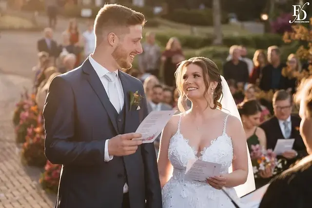 Noivos Nádia e Nikolas no altar ao ar livre com pôr do sol na Serra Gaúcha.