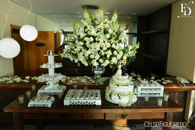 mesa de doces em madeira e flores brancas