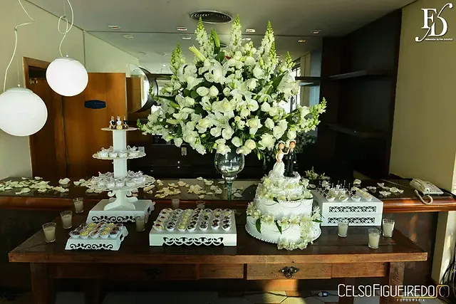 mesa de doces em madeira e flores brancas