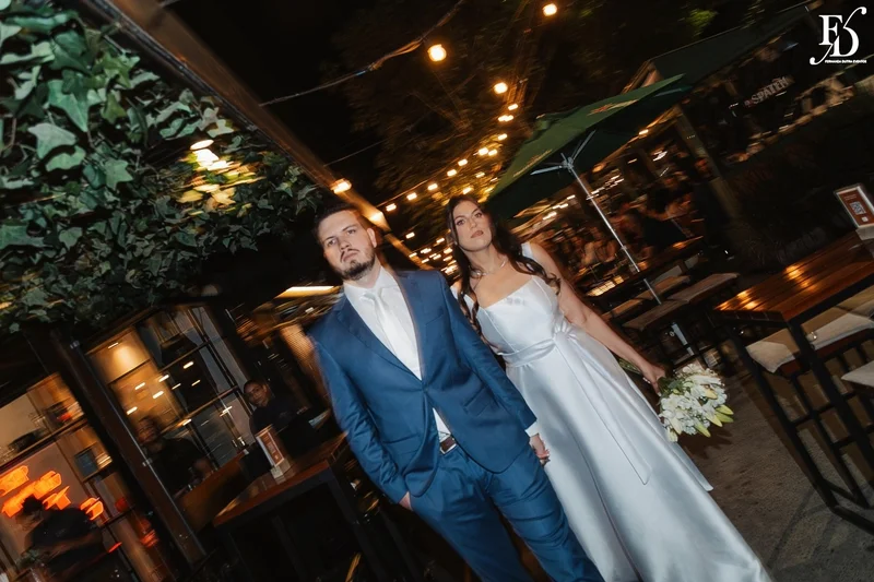 Casal Rafaella e Rafael sorrindo com buquê de lírios brancos após cerimônia de casamento