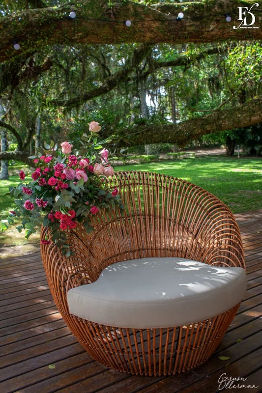 Lounge externo com sofá e varal de luzes sob a figueira.