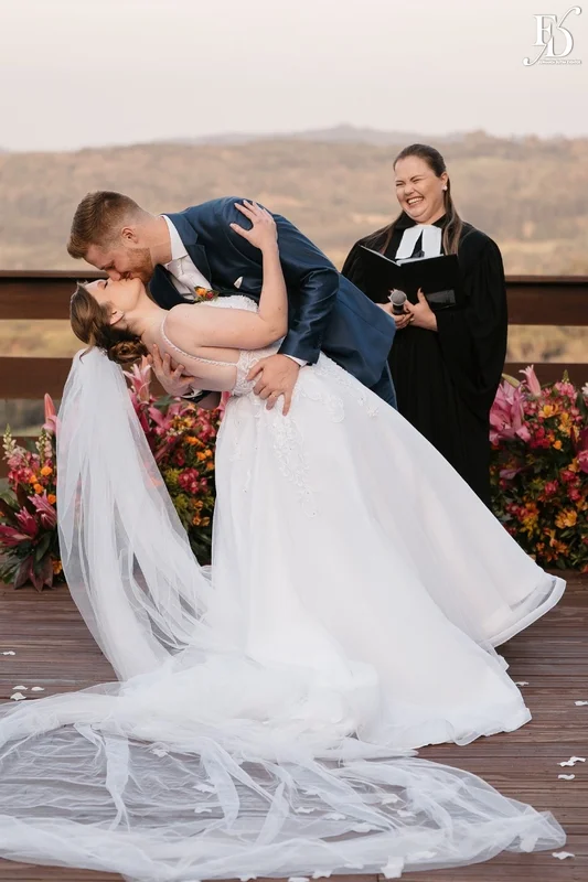 Noivos Nádia e Nikolas no altar ao ar livre com pôr do sol na Serra Gaúcha.