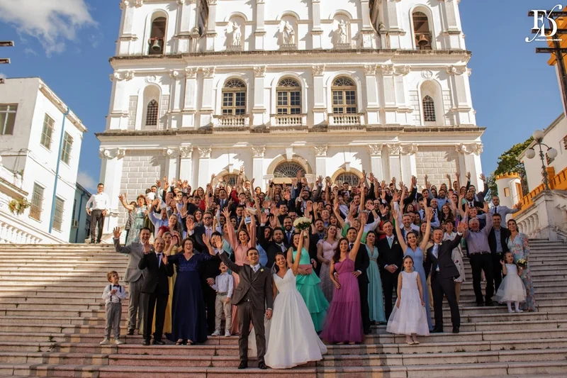 Grande grupo de convidados e noivos na escadaria da Basílica Nossa Senhora das Dores.
