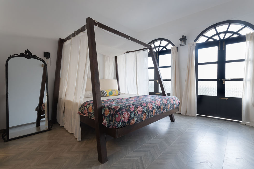 master bedroom with herringbone flooring and four-poster bed