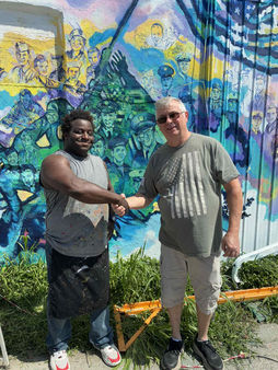 Shaking hands with Veteran Jeffrey Alan Huff Next to his Portrait on the MJL Veteran's Freedom Mural by Michael & Jennifer Lude 2025. Portrait Painted by Michael Lude