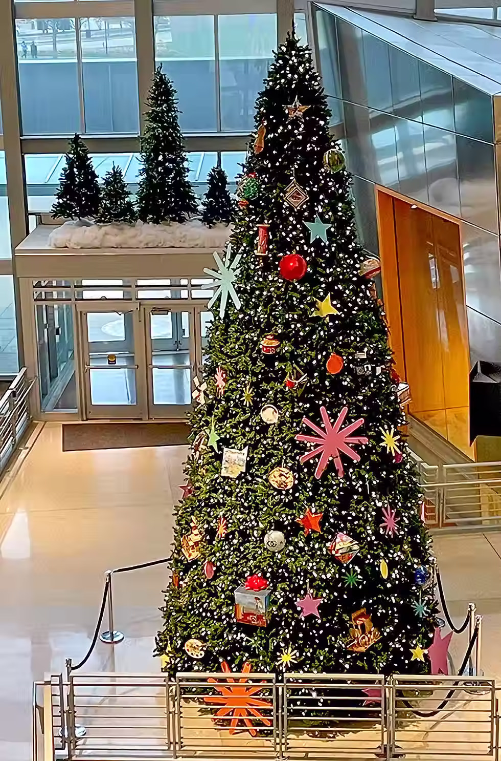 "A massive 25-foot Christmas tree in the Indiana State Museum Great Hall featuring 92 custom ornaments, including the Whitley County ornament by Michael and Jennifer Lude."