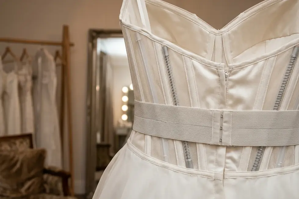 Internal boning and corset support structure inside a plus-size bridal sample gown.