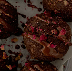 close up of mocha collagen balls with chocolate drizzle and crushed rose petals