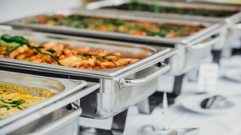 Close-up of buffet chafing dishes filled with assorted entrées, ready for guests at The Reign’s catered event.