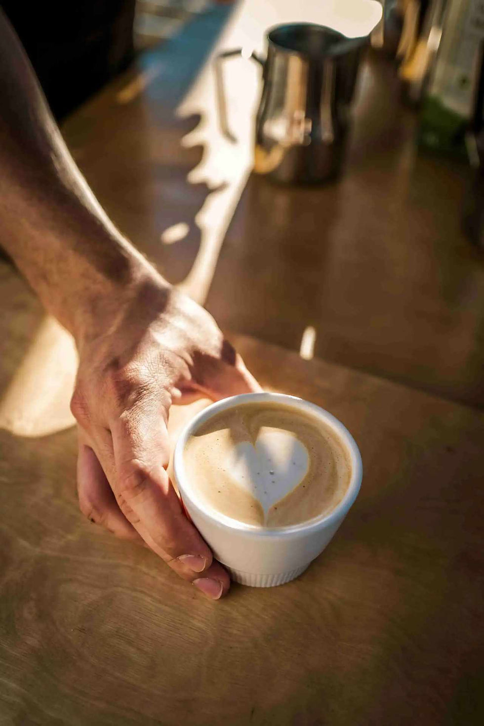 Hand reicht Tasse mit Latte Art