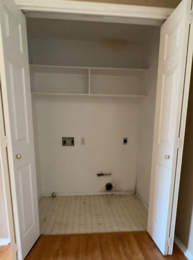 Efficient laundry space designed within a closet, featuring a washer and dryer, custom shelving, and smartaundry