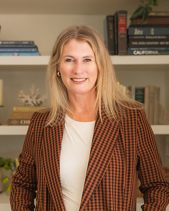 Jenny Ingram, California realtor smiling in front of bookshelves