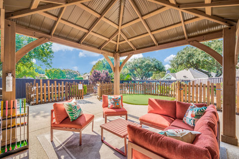 Coral cushioned patio furniture under a Sponge Bob Tiki gazebo designed for a shirt term rental.