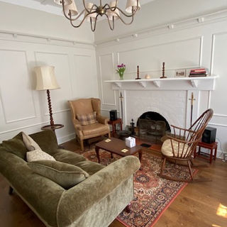 Living room with couch, seating and fireplace.