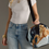 Thumbnail: Dark Blue Ski Trip Scene Duffel with a long strap over the shoulder of a woman wearing a white t-shirt and jeans.