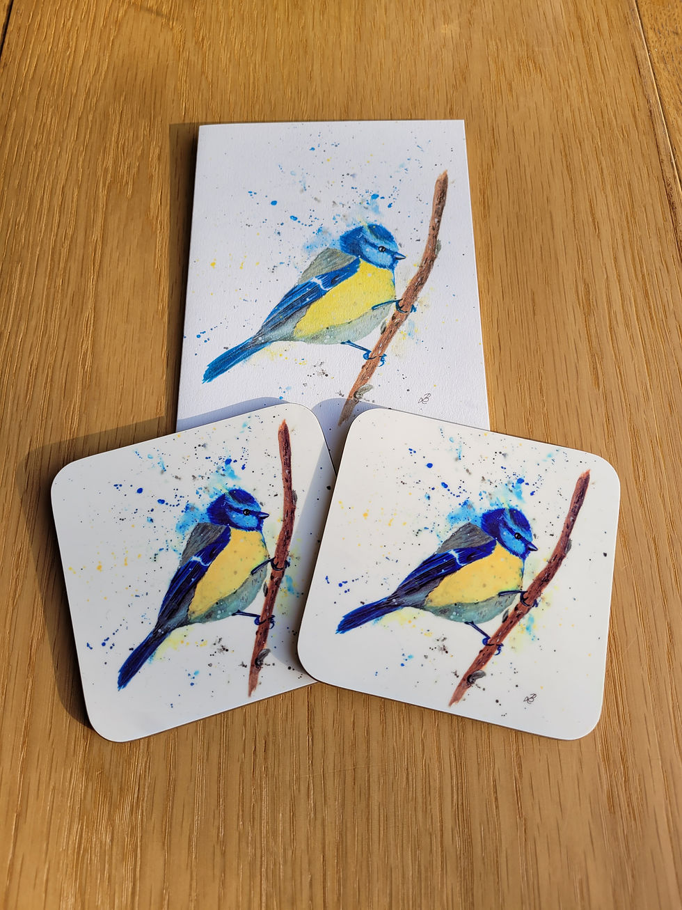 Thumbnail: Flat lay close up of two blue tit coasters and matching greetings card. Watercolour blue tit bird on white background.
