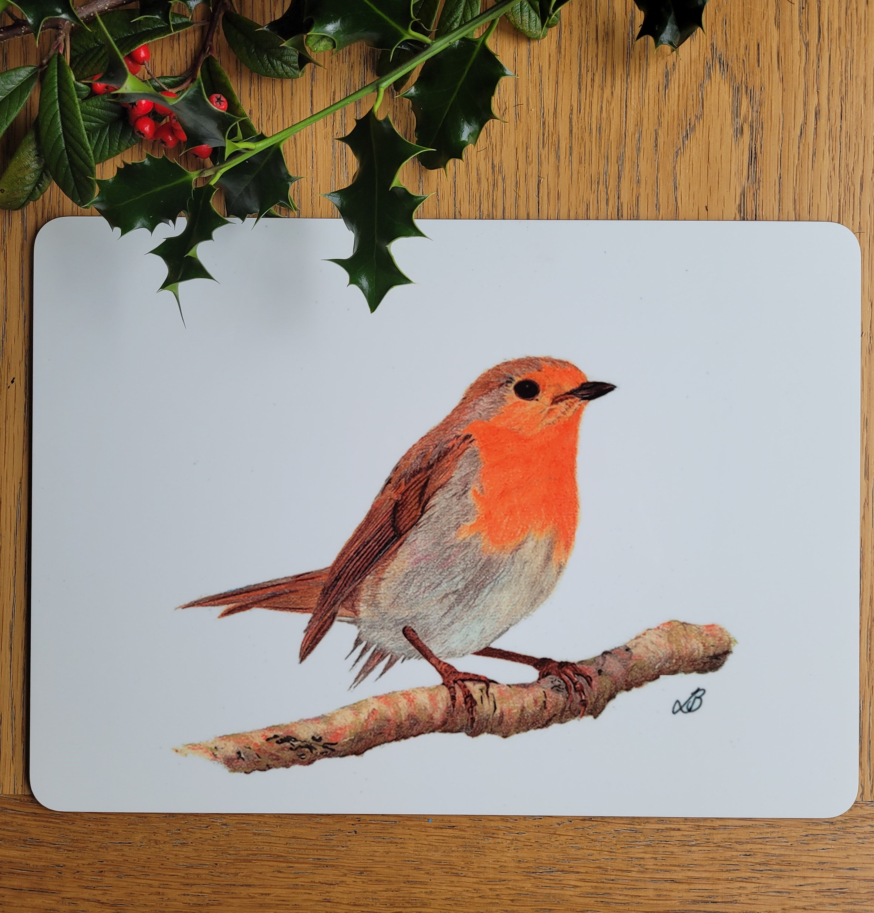 Close up of a large robin redbreast table mat. Coloured pencil drawing of a robin against a white background.