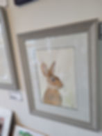 Thumbnail: Close up angled view (from RHS) of a framed Wild Rabbit painting. Original watercolour depicting an alert wild rabbit